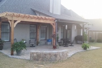 Paver patio with cedar pergola and stone sitting wall near me.